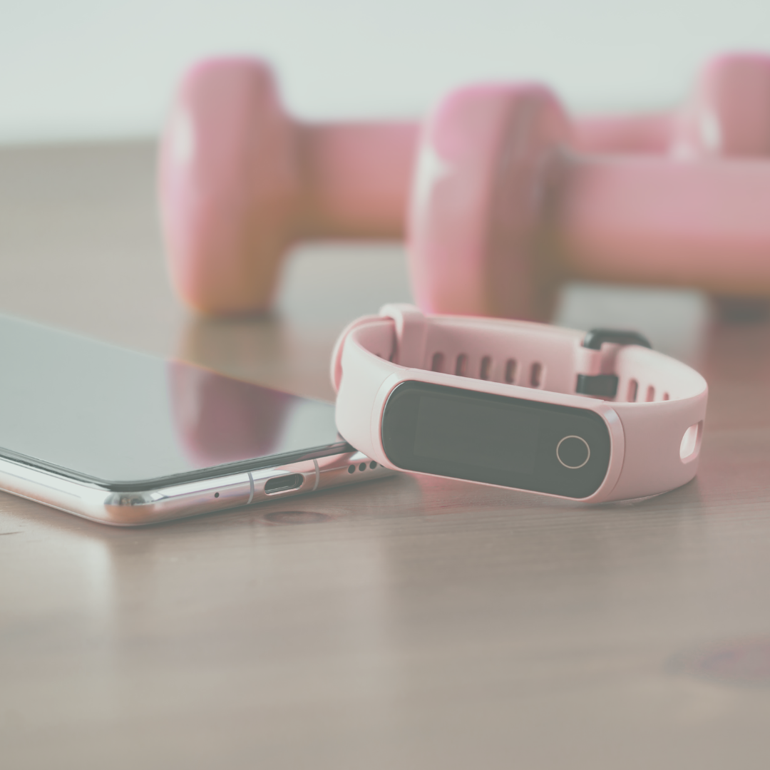 iPhone sitting next to a set of pink dumbbells with a pink fitness tracker leaning against them.