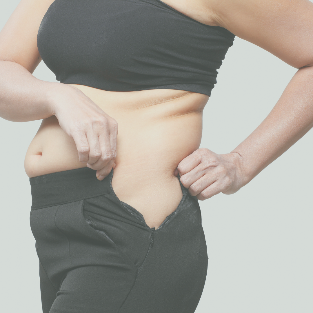 Image of a woman trying to get her pants to zip to signal she has gained weight.