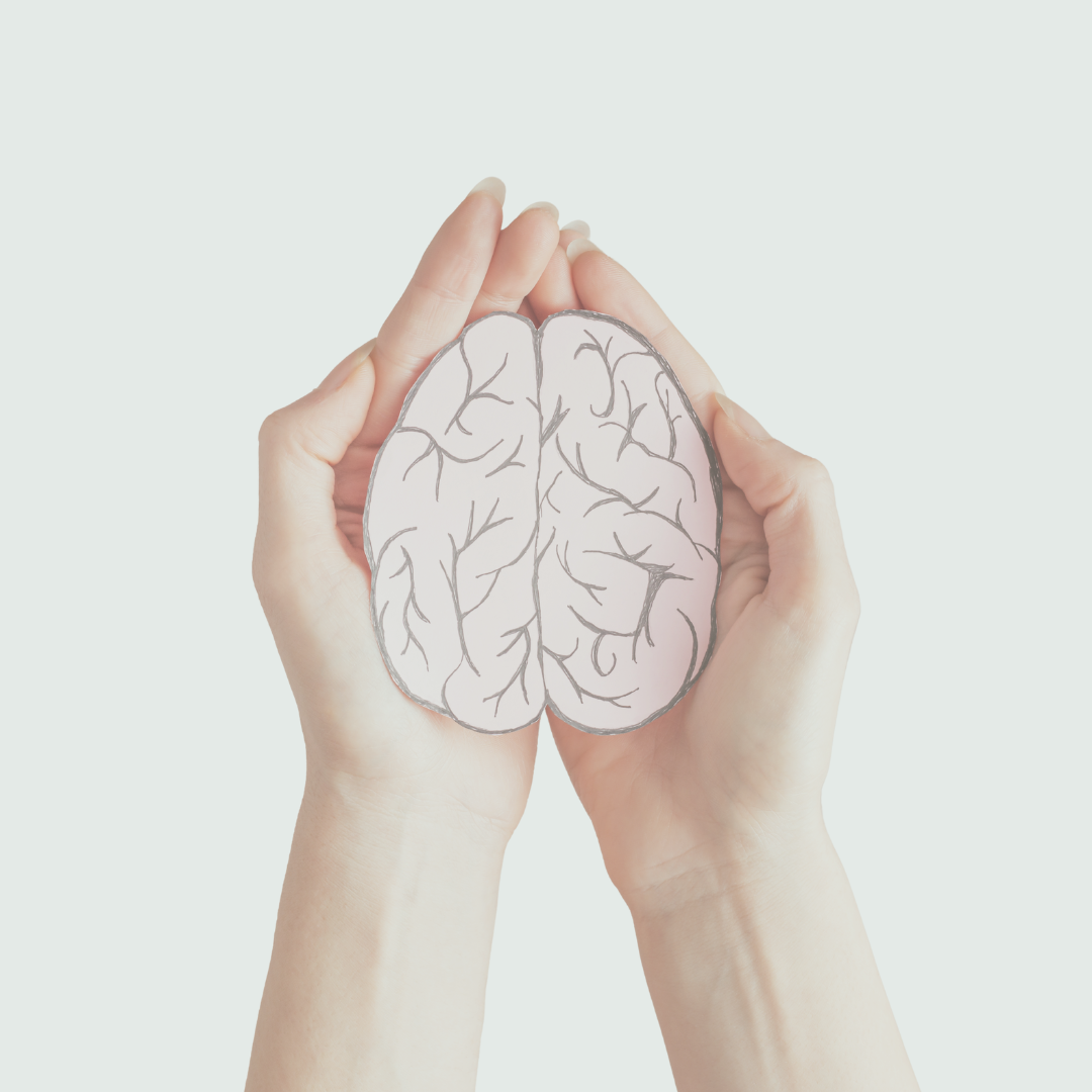 Picture of a woman's hands holding a picture cut out of a brain.